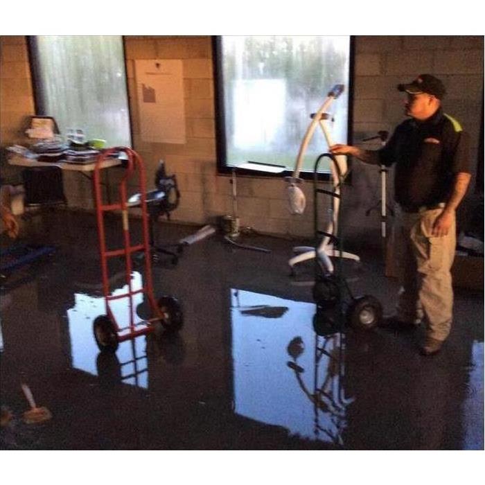 ServPro employee standing in water at at a commercial business