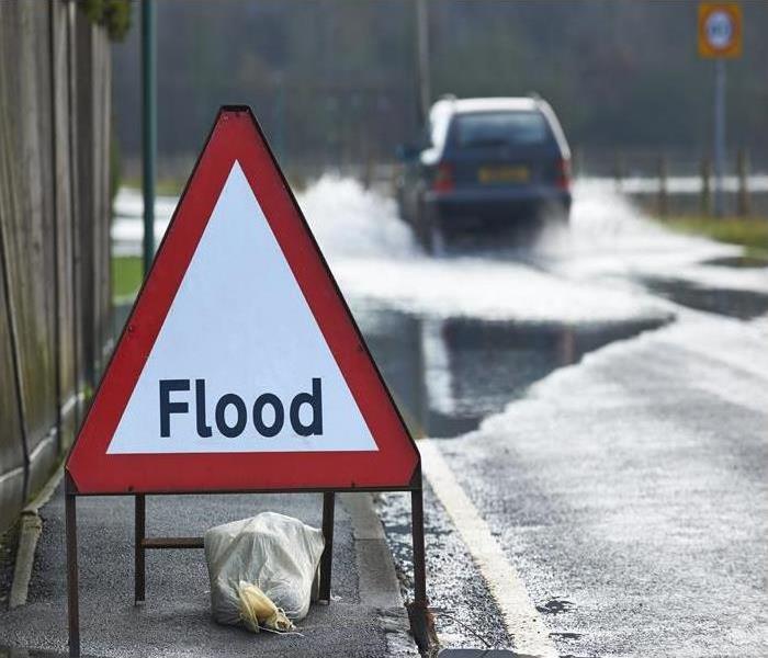 Flooded road with hazard signage